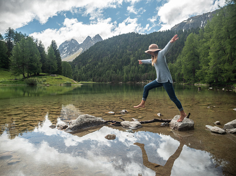 young man prepare to jump into the water of the clean river, swims, enjoys spending time on summer holidays. High quality photo