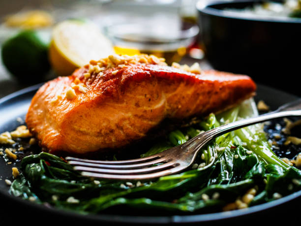 istock Fish dish - salmon steak with pak choi cabbage on wooden table 1296514578