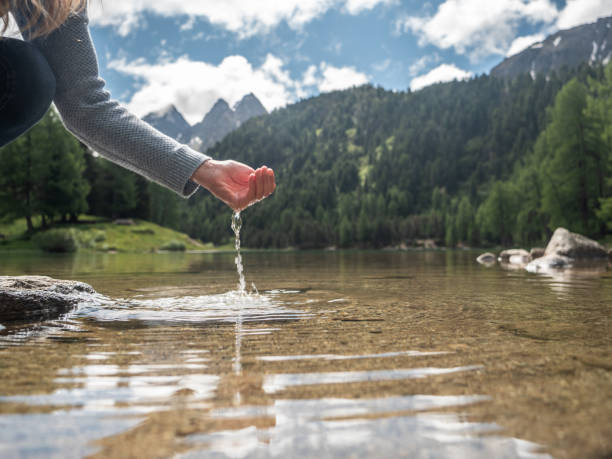 hands scooping water from alpine lake - mountain drop europe switzerland imagens e fotografias de stock