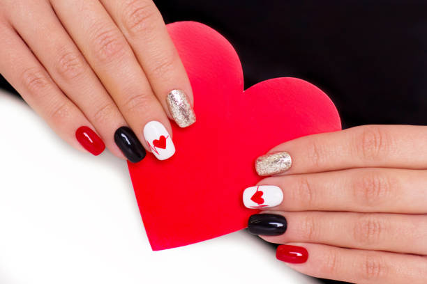 istock Female hands with romantic manicure nails, hearts design 1296515266
