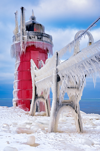 Winter landscape of the South Haven, Michigan Lighthouse and catwalk glazed in ice, Lake Michigan, USA
