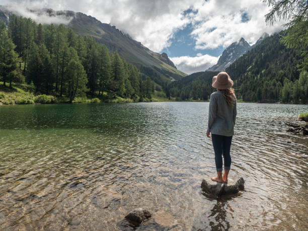 istock Woman contemplates alpine lake 1296515712