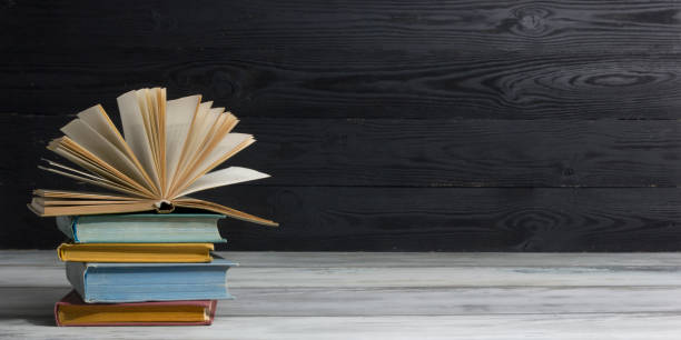 istock Open book, hardback books on wooden table. Back to school. Copy space. 1296515877