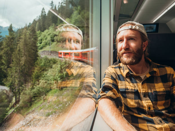 istock Man traveling by train looking from the window enjoying passing scenery 1296517103