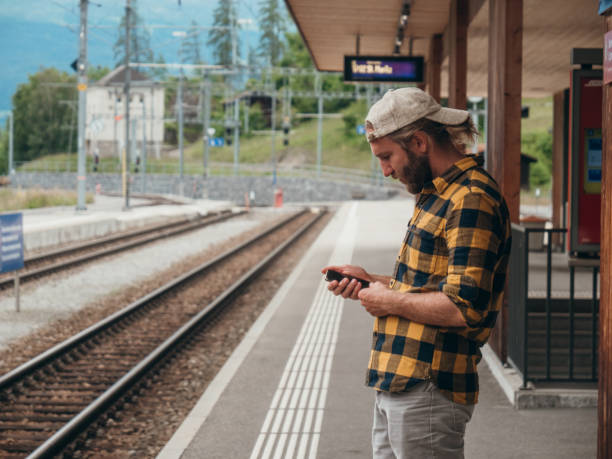 istock Man checks phone at train station 1296517145