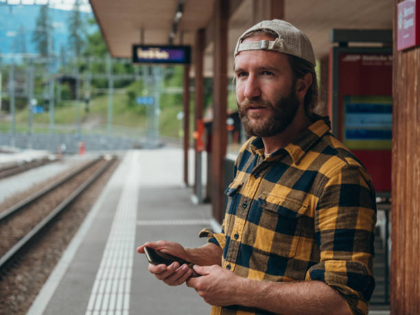 Man checks phone at train station