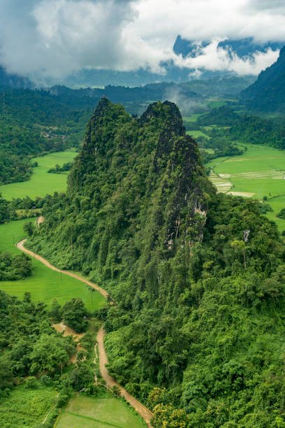 vista lussureggiante e verde sulle montagne di vang vieng, in laos, durante la stagione delle piogge. - vang vieng foto e immagini stock