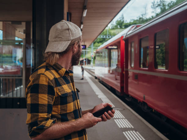 istock Man checks phone at train station 1296518073