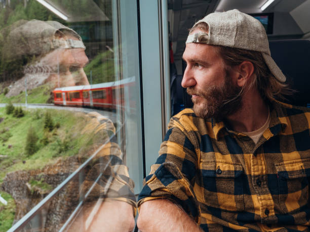 istock Man traveling by train looking from the window enjoying passing scenery 1296518074