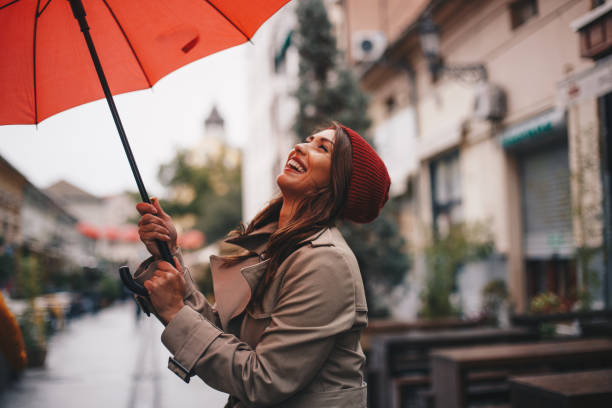 istock Young woman is smiling, opening umbrella. 1296518582