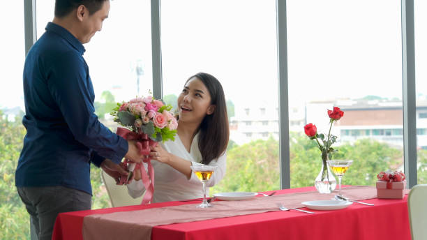 istock Romantic couple giving gift to lover at restaurant 1296519460