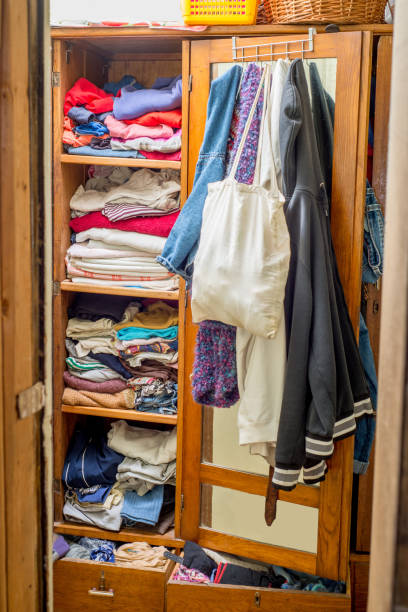 istock Wardrobe overflowing with clothes and things. Second hand reuse. Decluttering and cleaning the cabinet 1296520162