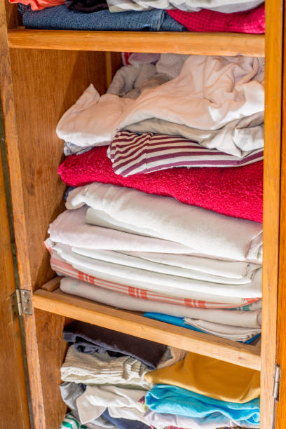 istock Linen closet with bed linen and clothes in piles. Decluttering old things 1296520164