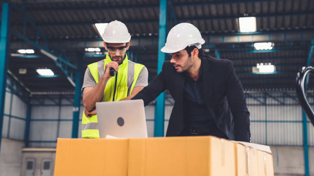 istock Two factory workers working and discussing manufacturing plan in the factory . 1296525143