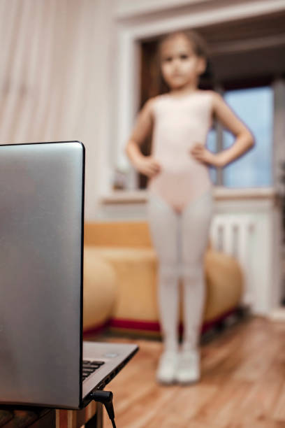 istock Young ballerina practicing classic choreography during online class at home, self-isolation 1296527003