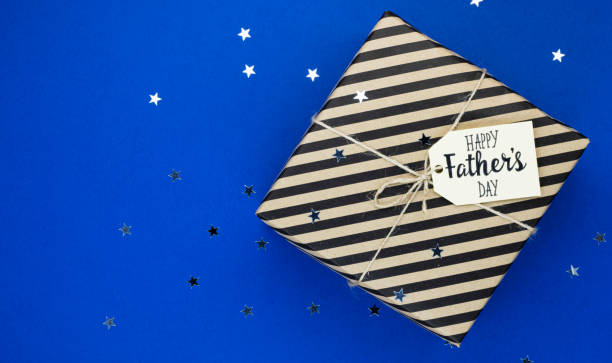 istock Striped gift box with ribbon on a blue background. Copy space top view Father's Day special occasion gift 1296528231
