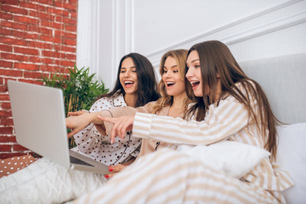 istock Three girls watching something on a laptop and looking excited 1296529187