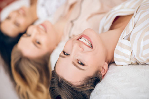 istock Three beautiful girls slying on bed and smiling 1296529306
