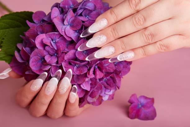 istock Hands with long artificial french manicured nails 1296531548