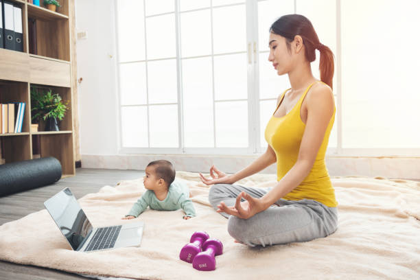 노란 스포츠웨어에 스포티 한 아시아 여자는 딸 아기와 함께 바닥에 앉아있다 - aerobics beautiful bottle body 뉴스 사진 이미지
