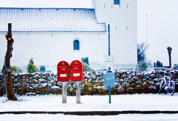 A snowy and windy day for two red letter boxes
