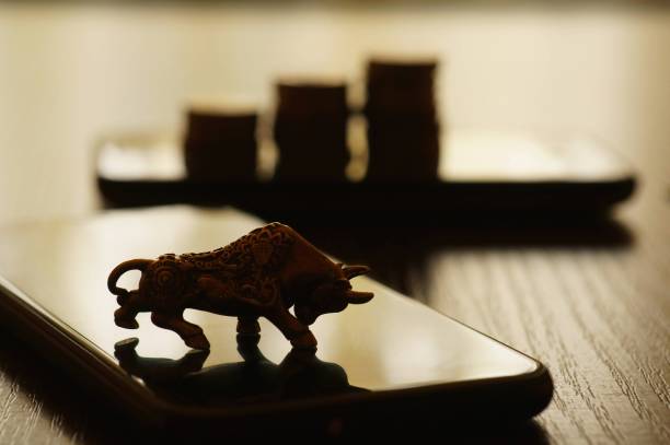 istock Metal bull and mobile phone on the table. 1296534012