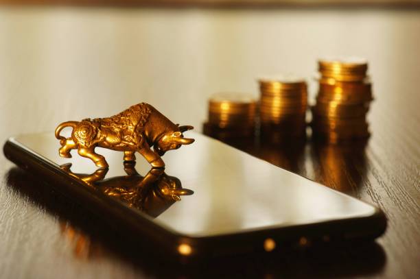 istock Metal bull and mobile phone on the table. 1296534064