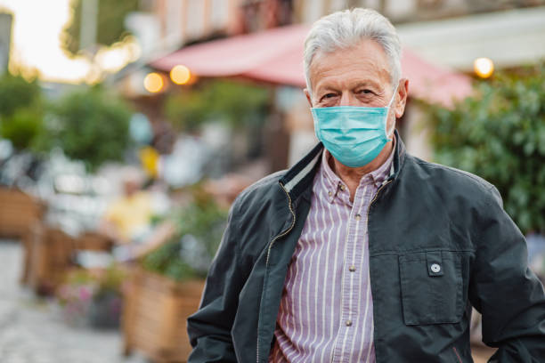 istock Portrait of senior man with face mask 1296536896