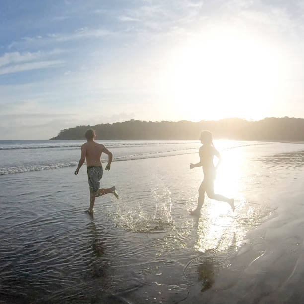 istock Friends run into Pacific Ocean in the morning 1296537595
