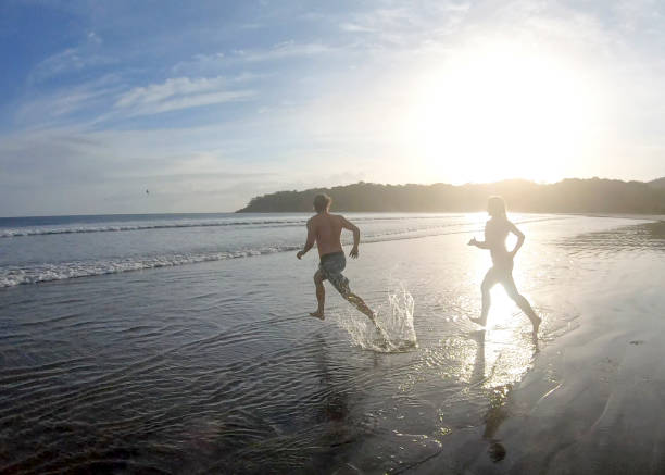 istock Friends run into Pacific Ocean in the morning 1296537642