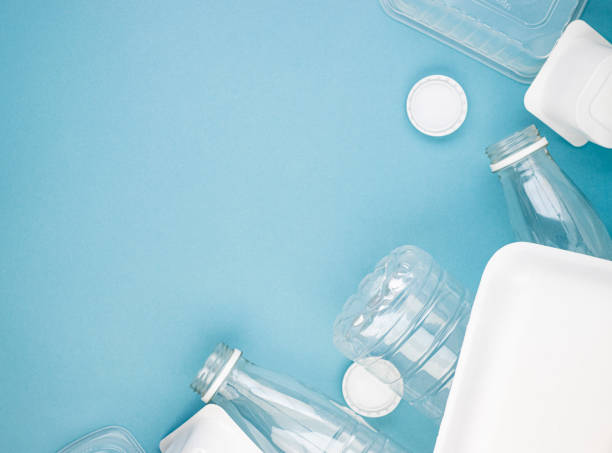 istock Empty plastic bottles with white lids, packages and dishes in a pile on a blue background 1296538433