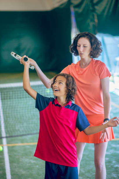 istock Dark-haired boy having a tennis workout with his coach 1296538864