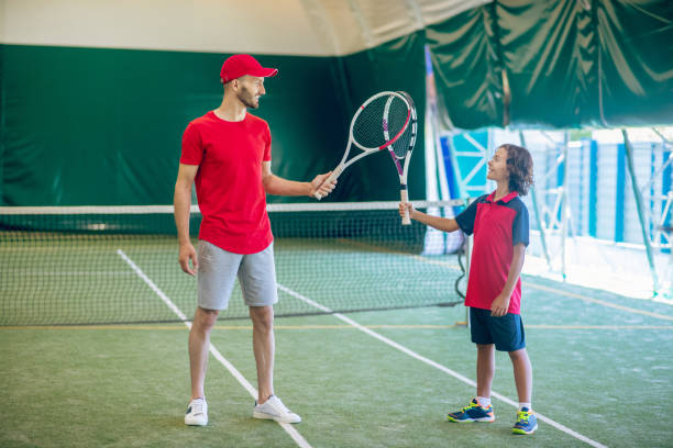 istock Coach in a red cap and a boy having a workout and feeling involved 1296538910