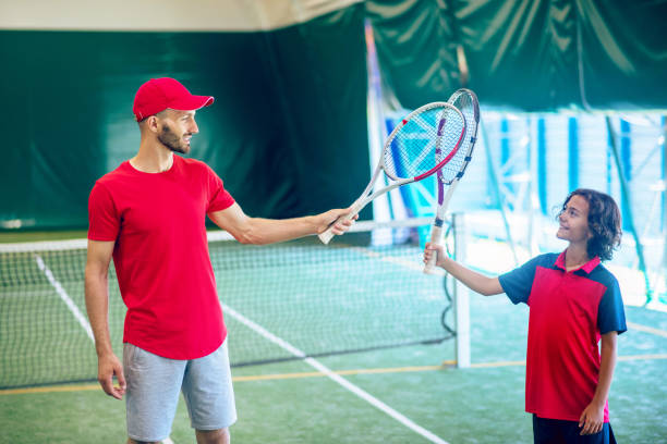 istock Coach in a red cap and a boy having a workout and feeling involved 1296538926