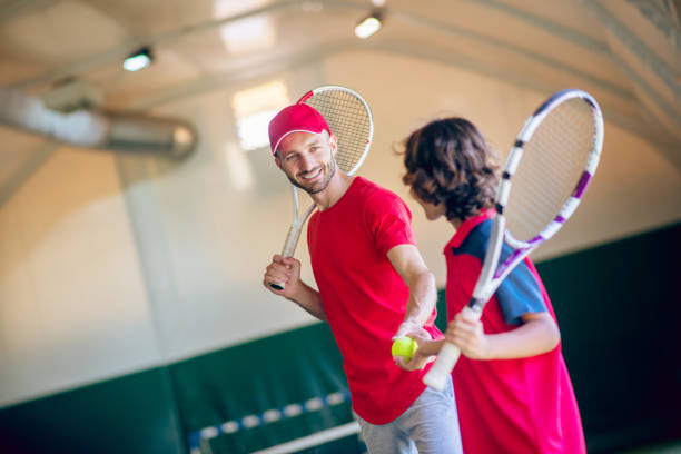 istock Young bearded man in a red cap talking to a boy before the game 1296538969