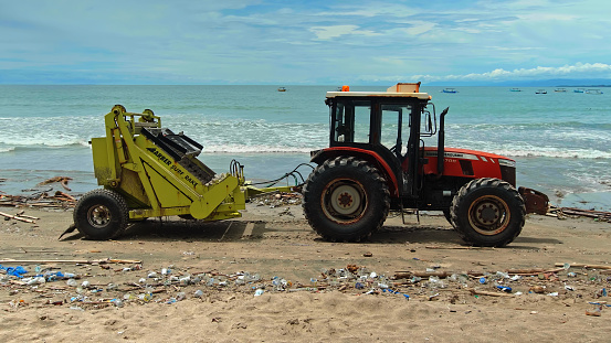 Kuta, Badung, Bali, Kuta Beach Indonesia - 4, January 2021: Tractor technic for cleaning the sea beach from garbage stands on the sand after throwing plastic garbage from the sea on the island of Bali in the city of Kuta