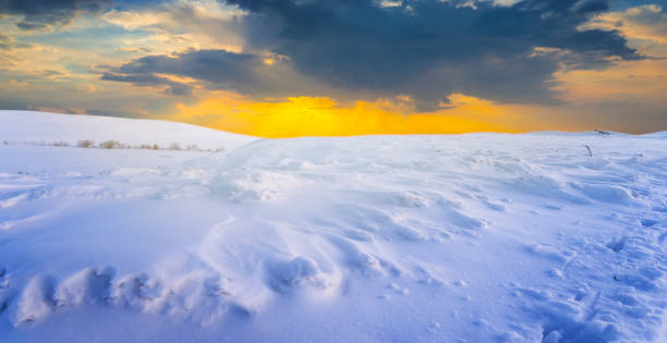 istock plain covered by a snow in the light of evening sun, winter field at the dramatic sunset 1296541706