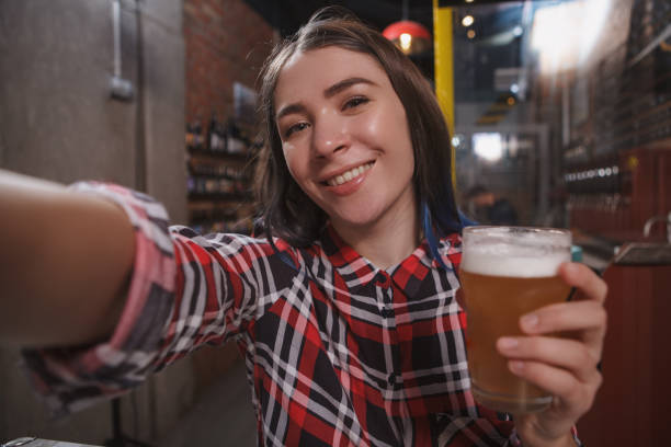 istock Woman drinking at beer pub 1296542482