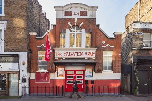 London, UK - 1 December 2020: Woman walking past Salvation Army building in Notting Hill during second national COVID lockdown