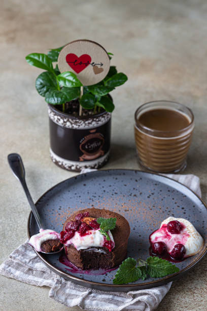 istock Mini chocolate cake or brownie with cream, cherry and mint on a ceramic plate and cup of coffee. Chocolate fondant. Breakfast or dessert for Woman or Mother Day. 1296551691