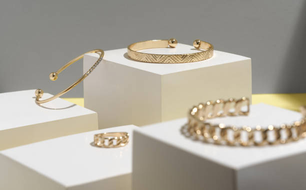 istock Golden bracelets and ring on white cubic blocks with copy space 1296552079