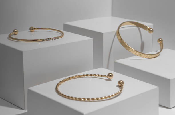 istock Three modern Golden bracelets on white geometric white blocks 1296552085
