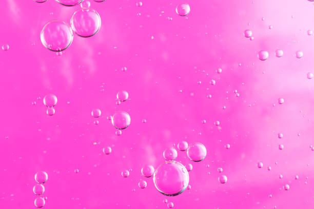 istock oil drops on water on a pink background 1296553007