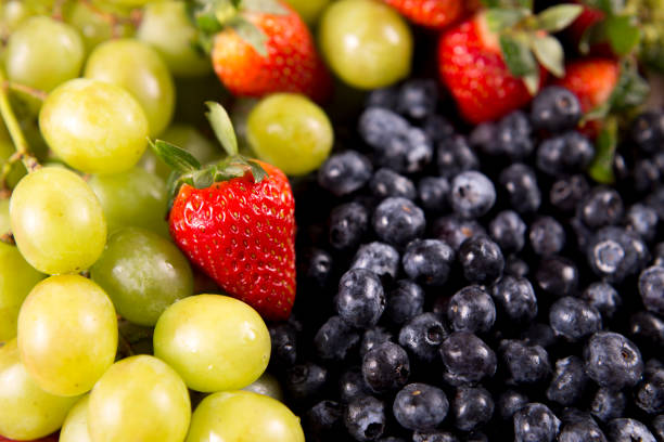 Fruit background of strawberries, grapes and blue berries.