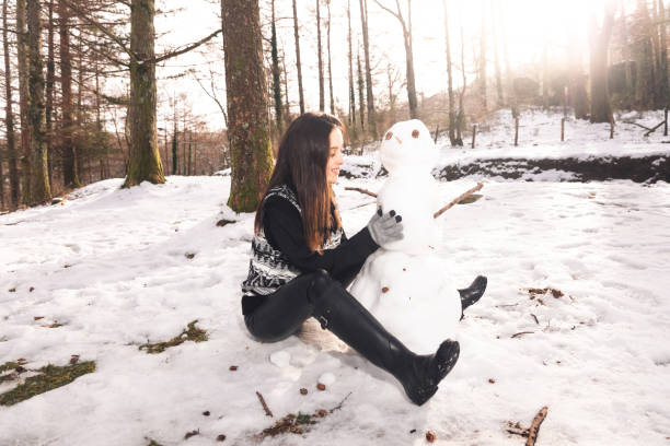 istock Girl building a snowman 1296555559