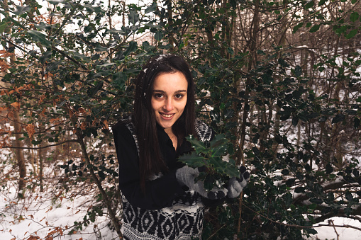 Young woman portrait between trees covered with snow