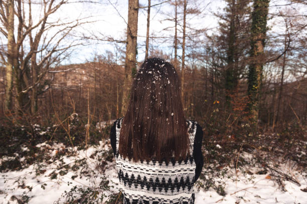 Young caucasian woman enjoying on a snowy forest.