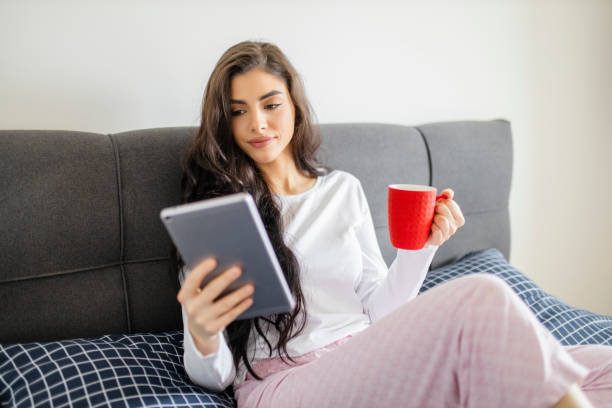 istock Young woman drinking coffee and resting in bed 1296556942