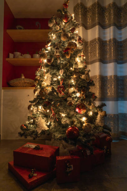 istock A Christmas tree illuminated with gifts 1296562213