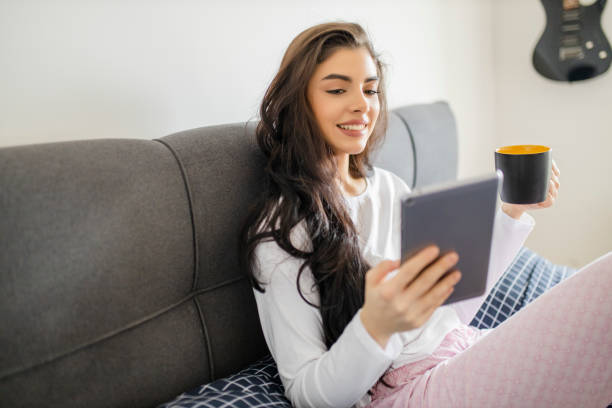 istock Young woman drinking coffee and resting in bed 1296563170